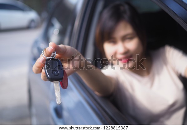 A woman\
giving car key. Car rent or sale.   \
