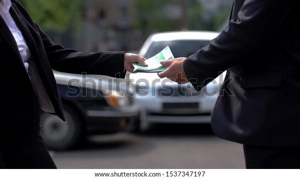 Woman giving euros to man on cars background, rent\
agreement, business deal