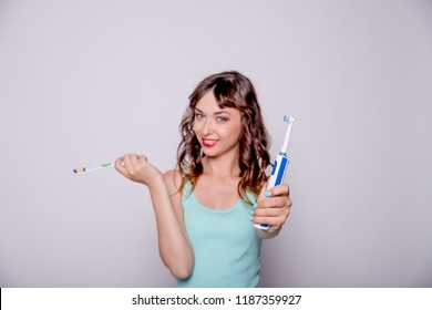 Woman giving me electric toothbrush. Selective focus.Happy woman cleaning her oral cavity caring about dental health.Choice between traditional toothbrush and an electric toothbrush.Copy space