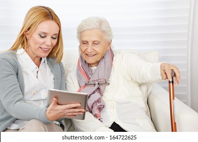 Woman giving senior woman introduction to internet with a tablet computer - Powered by Shutterstock