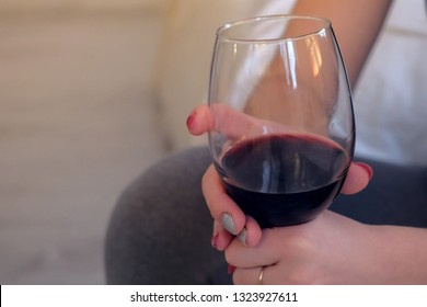 Woman with a glass of red wine in her hands, hands close-up. - Shutterstock ID 1323927611