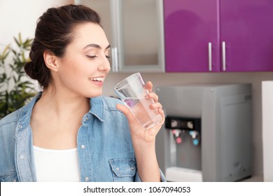 Woman With Glass Of Water From Cooler In Office