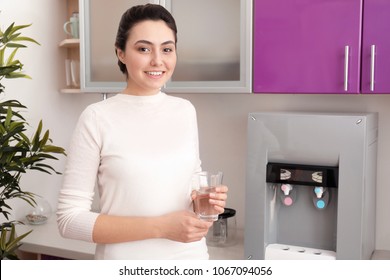 Woman With Glass Of Water From Cooler In Office