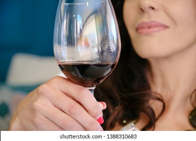 woman with a glass of wine in front of her lips