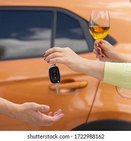 A Woman With A Glass Of Wine Gives The Car Keys To A Sober Driver. Designated Driver Service