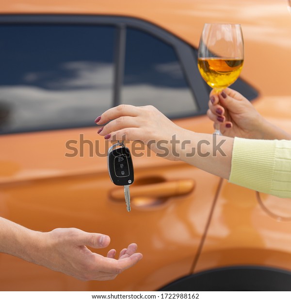 A woman with a glass of wine\
gives the car keys to a sober driver. Designated Driver\
Service