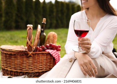 Woman With Glass Of Wine Having Picnic In Park, Closeup