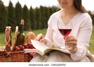 Woman With Glass Of Wine Having Picnic In Park, Closeup