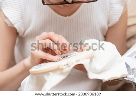 Woman with glasses doing embroidery