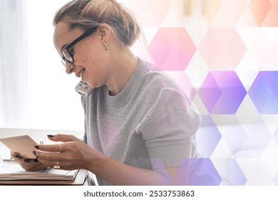 Woman with glasses multitasking, holding documents and phone. Caucasian woman, focused and busy, managing tasks efficiently. Professional and organized woman. Digital device and communication. - Powered by Shutterstock