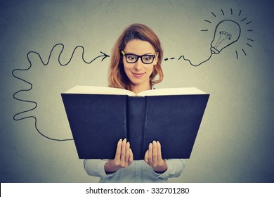 Woman in glasses reading big book comes up with an idea 
