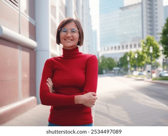 Woman in glasses and red turtleneck, dressed in business style, stands in center of Frankfurt, surrounded by modern buildings and urban life, embodying professionalism and confidence - Powered by Shutterstock