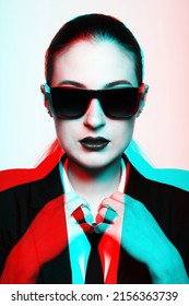 Woman With Glossy Hair, Sunglasses And Classic Black Suit With Tie Looking To Camera. Close-up Fashion Portrait In RGB Color Split. RGB Effect Make Reflection Of Model Face In Red And Blue Colors