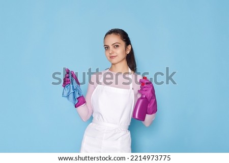 woman in gloves and cleaner apron with sponge and detergent sprayer