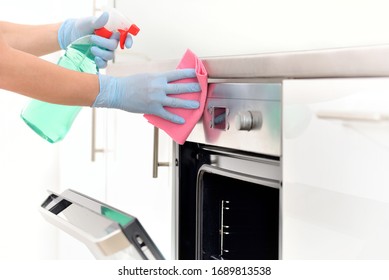 Woman In Gloves Cleaning Kitchen.