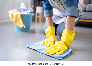 woman with gloves cleans the floor close up