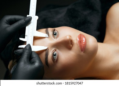 Woman In Gloves Making Measure With Calipers For Permanent Brow Makeup For Woman With Perfect Skin. Closeup Shot
