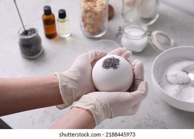 Woman In Gloves With Self Made Bath Bomb At Grey Table, Closeup