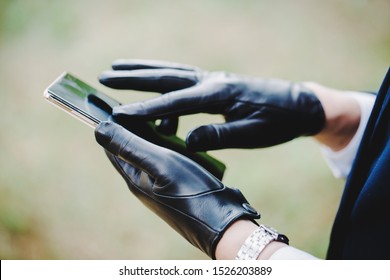 Woman In Gloves With Touchscreen Uses Smartphone.