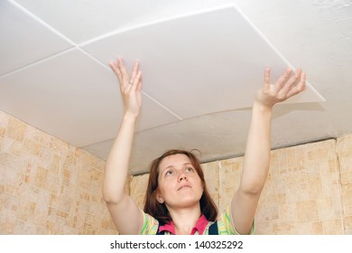 Woman Glues Ceiling Tile At Home