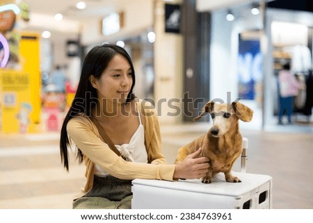 Woman go out with her dachshund dog at shopping mall