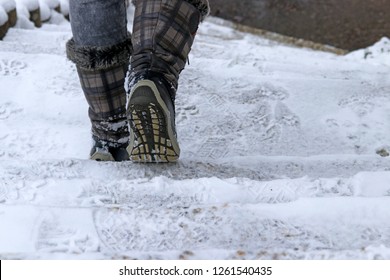 A Woman Goes Down A Staircase In Winter. In Winter There Is A Danger Of Slipping On A Snow-covered Staircase. 
