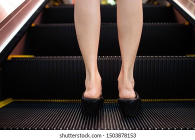 Woman Going Up The Escalator