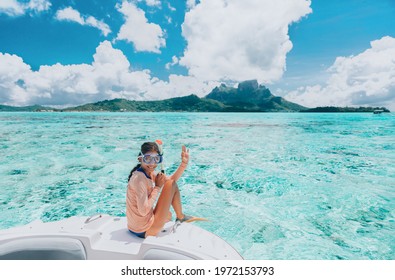 Woman going snorkeling in Bora Bora island, Tahiti, French Polynesia. Happy tourist on luxury vacation getaway on cruise ship luxury yacht private charter swim tour of coral reefs.