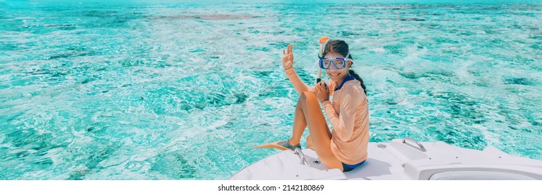 Woman going snorkeling in pefect clear water at coral reef. Happy tourist on luxury vacation getaway on cruise ship luxury yacht private charter swim tour of coral reefs
