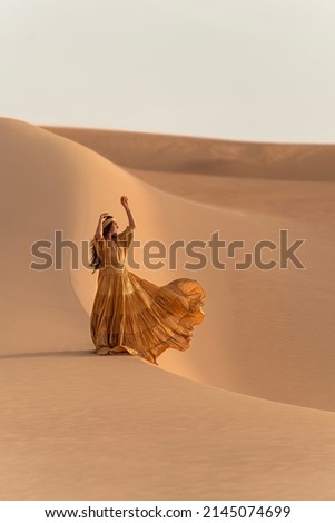 Woman with Golden Dress Dancing on the Sand Dunes