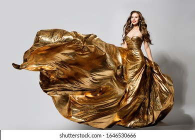 Woman In Golden Dress Flying On Wind, Happy Beautiful Lady In Fluttering Sparkling Gold Gown