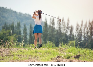 Woman Golfer Finished Golf Swing. Close Up Of Female Golf Player Swinging Golf Club On Fairway During Day Time.