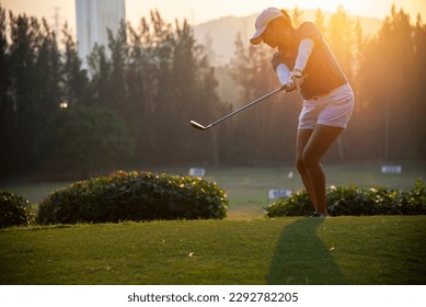 Woman golfer hits an fairway shot towards the club house,Lifestyle Concept. Sport Concept
