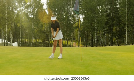 Woman golfer hits an fairway shot towards the club house. - Powered by Shutterstock