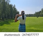 Woman Golfing On A Sunny Summer Day In A Green Field