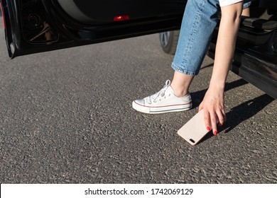 Woman Got Into A Car And Dropped Smartphone On Asphalt, Broke The Glass On The Back Cover, Picking Broken Phone From The Floor.