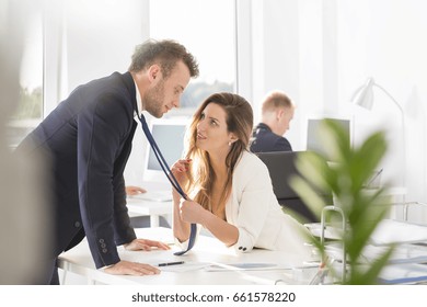 Woman Grabbing Man's Tie And Flirting At Work