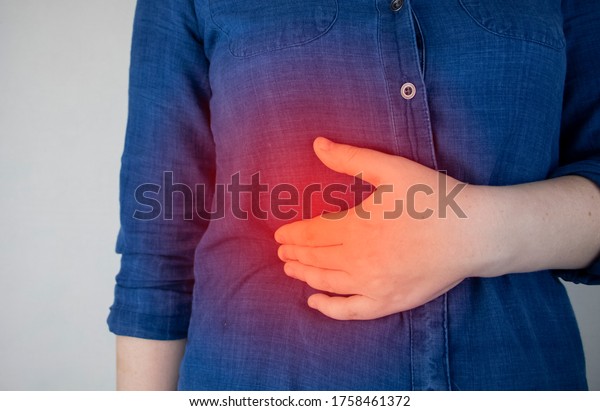 A\
woman grabs his right side under the ribs. Pain in the liver. Pain\
syndrome in liver disease. Hepatologist\
examination