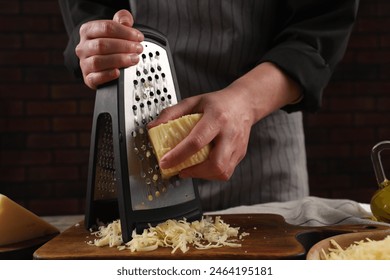 Woman grating cheese at wooden table, closeup - Powered by Shutterstock