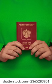 Woman in green jacket holds red Russian biometric passport. Female hands. Concept of patriotism, fatherland, immigration, obtaining citizenship of Russia, travel, trip, tourism, Copyspace. Copy space - Shutterstock ID 2365283851