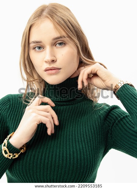 Woman in green knitted turtleneck on white\
background. Soft high collar.\
Vertical
