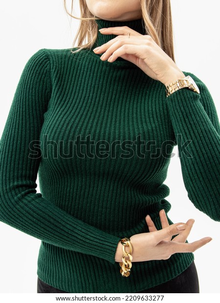Woman in green knitted turtleneck on white\
background. Soft high collar. Vertical. Knitwear viscose noodles.\
Jacket with long sleeves