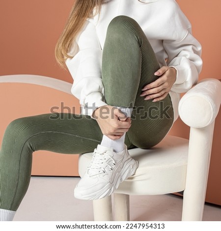 Woman in green leggings and white sneakers. Square. Casual sports style