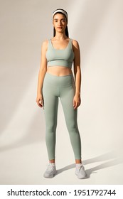 Woman in green sports bra and yoga pants activewear apparel full body