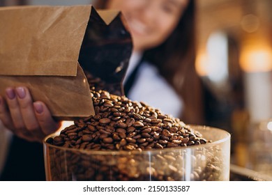 Woman grinding coffee in coffee machine - Powered by Shutterstock