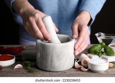 Woman grinding coriander at wooden table, closeup - Powered by Shutterstock