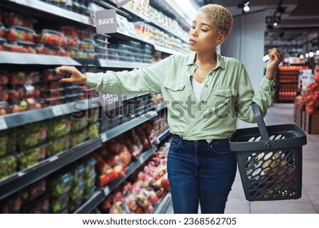 Woman, grocery shopping and fruits choice, discount and sale or wholesale promotion for healthy food and basket. African customer with strawberry package in retail, convenience store or supermarket