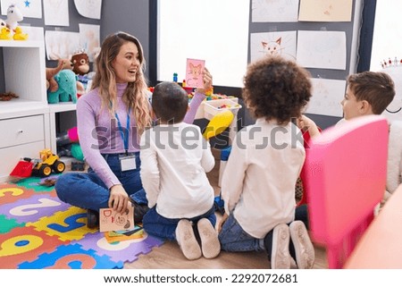 Woman and group of kids having vocabulary lesson with word cards at kindergarten