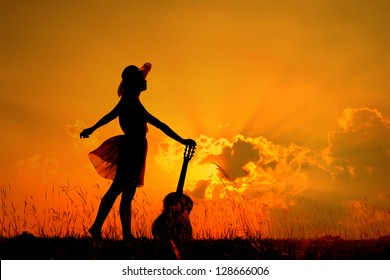 Woman And Guitar With Sunset Silhouette