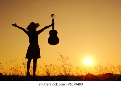 Woman And Guitar With Sunset Silhouette